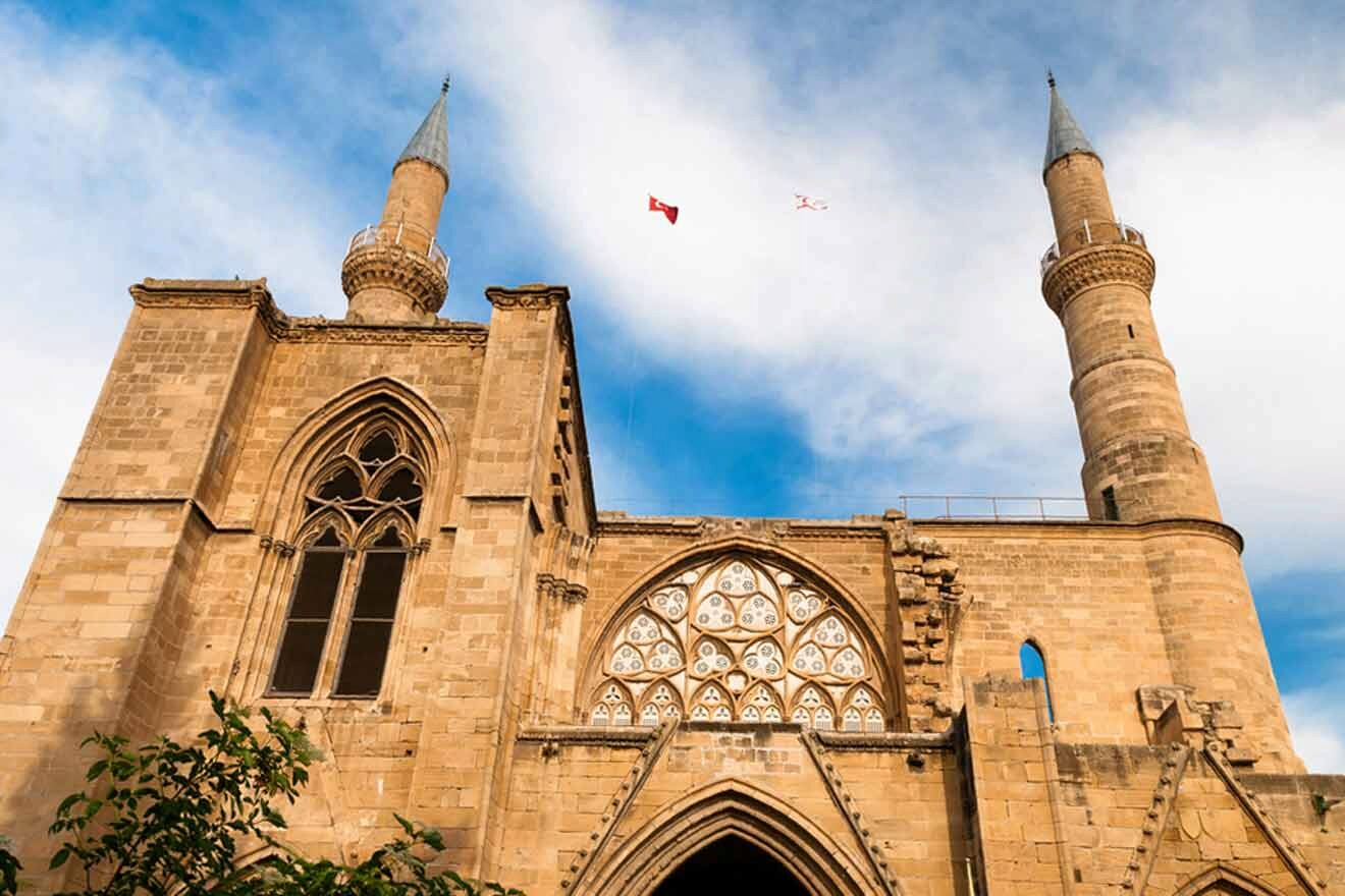 A church with two towers and a flag flying in the sky.