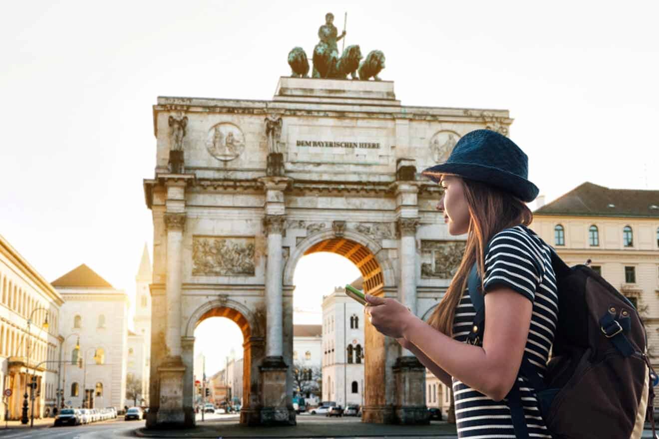 A woman looking at her phone in front of the triumphal arch