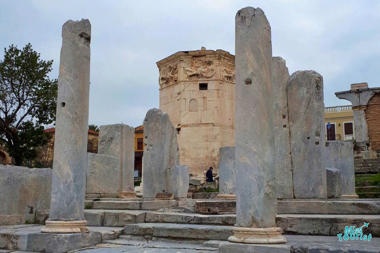 A group of pillars in front of a tower.