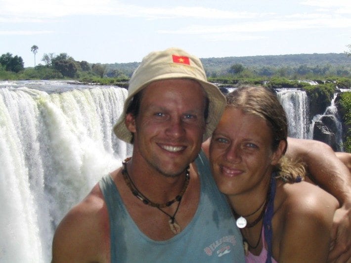 man and woman standing in front of a waterfall