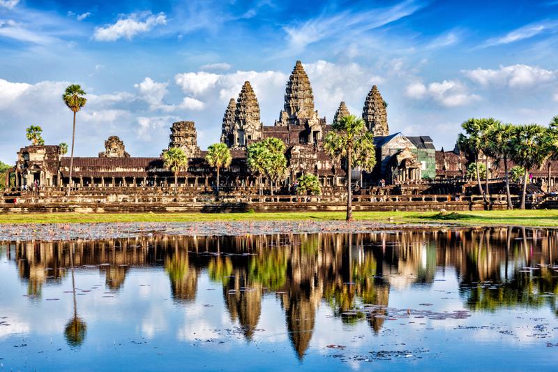 angkor wat next to a body of water with reflections