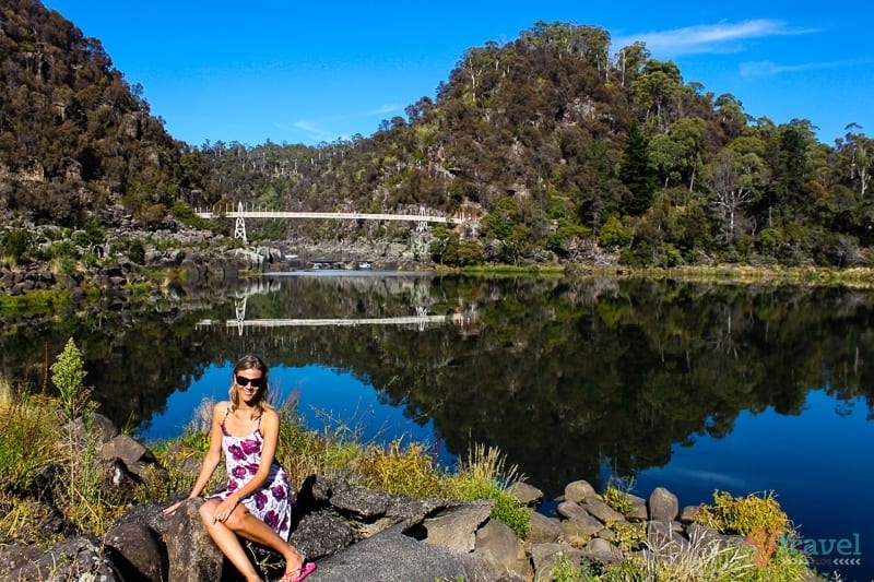 caz sitting on rock with water behind her at Cataract Gorge