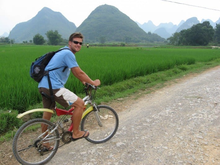 A man riding a bike down a dirt road