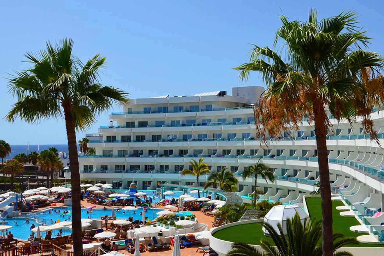 An aerial view of a hotel with a pool and palm trees.