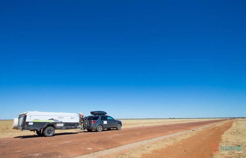 A car parked on the side of a dirt road