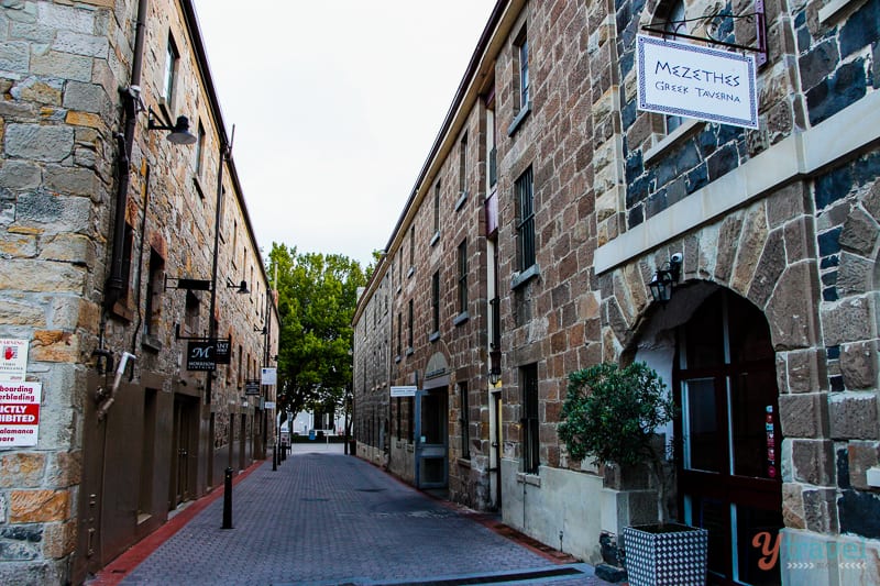 A brick building with a sign on the side of the street