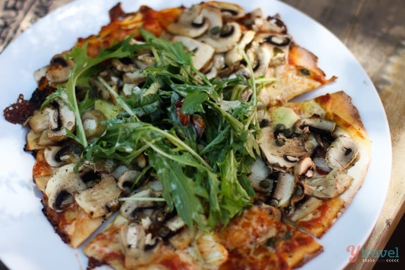 a pizza with mushrooms and rocket