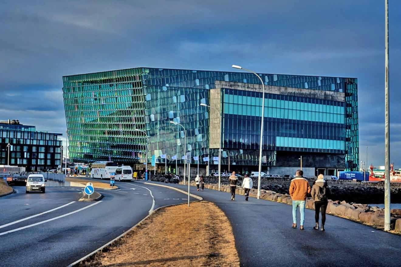 people walking down a street near a building.