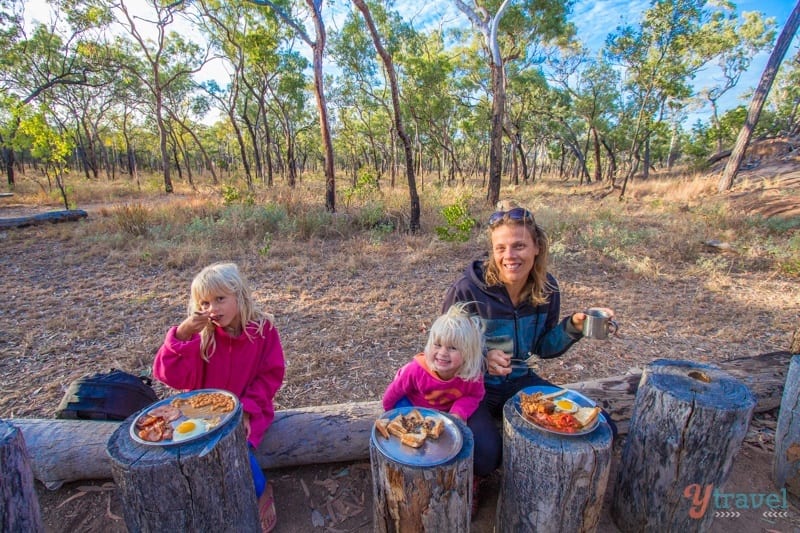 people eating food on logs