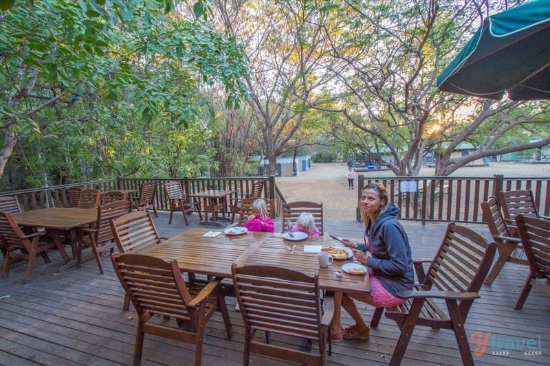 family eating breakfast at table on shady deck