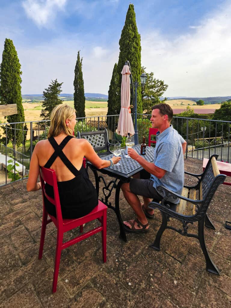 caz and craig cheersing on patio with tuscany views