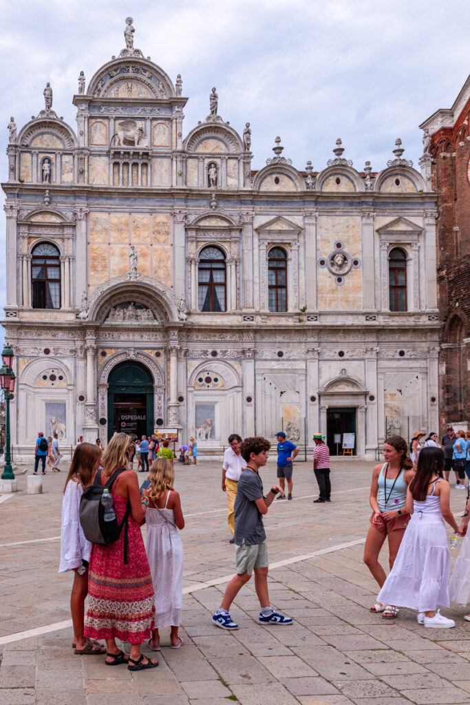 groups of people standing outside venetian hospital in the square