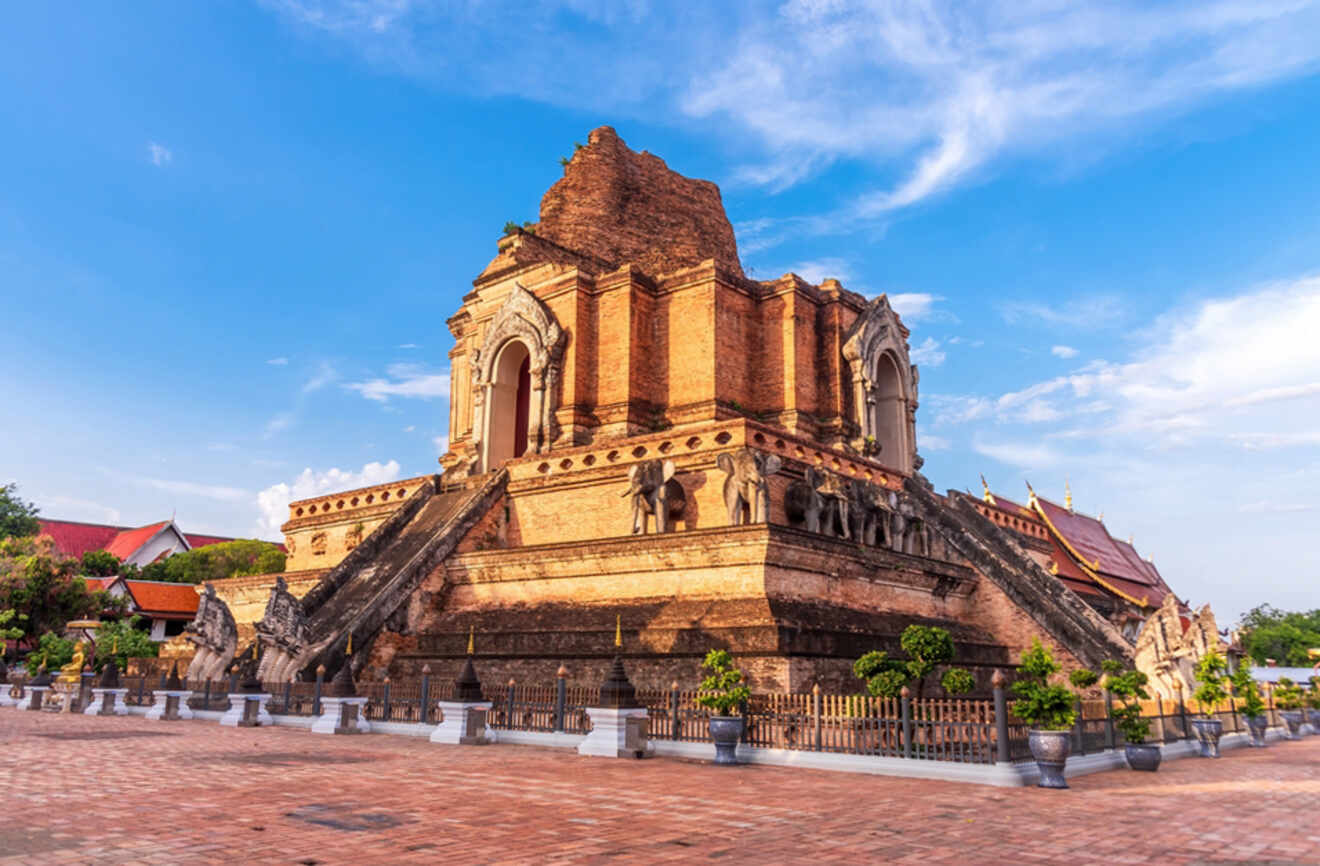 The remains of the ancient Wat Chedi Luang with a massive chedi in a state of graceful ruin, standing tall against a blue sky in Chiang Mai's Old City.