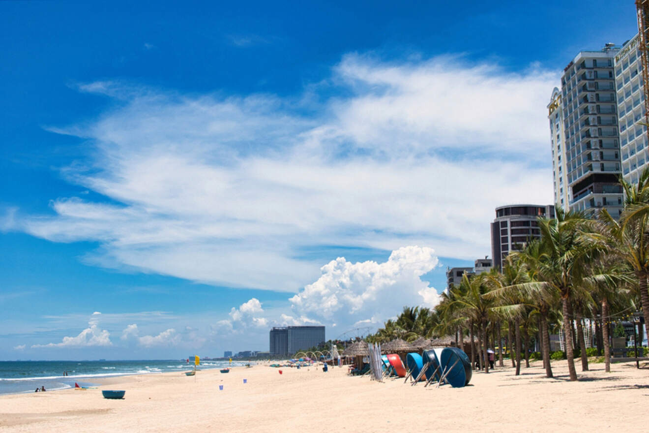 The beach in da nang is lined with umbrellas and chairs.