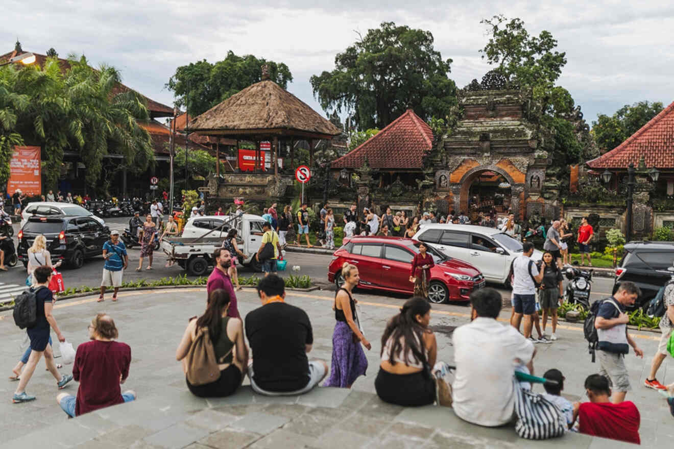 A crowd of people sitting on steps in front of a temple.