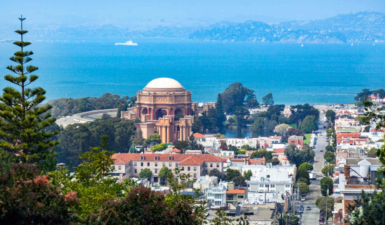 The serene view of the Palace of Fine Arts and surrounding greenery in the Pacific Heights neighborhood, overlooking the clear blue waters of San Francisco Bay.