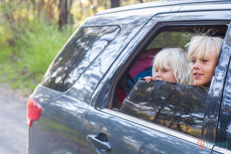 two young girls with head out  of car window