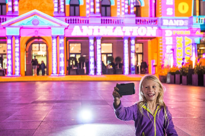 child taking selfie in front Customs House during Vivid Sydney