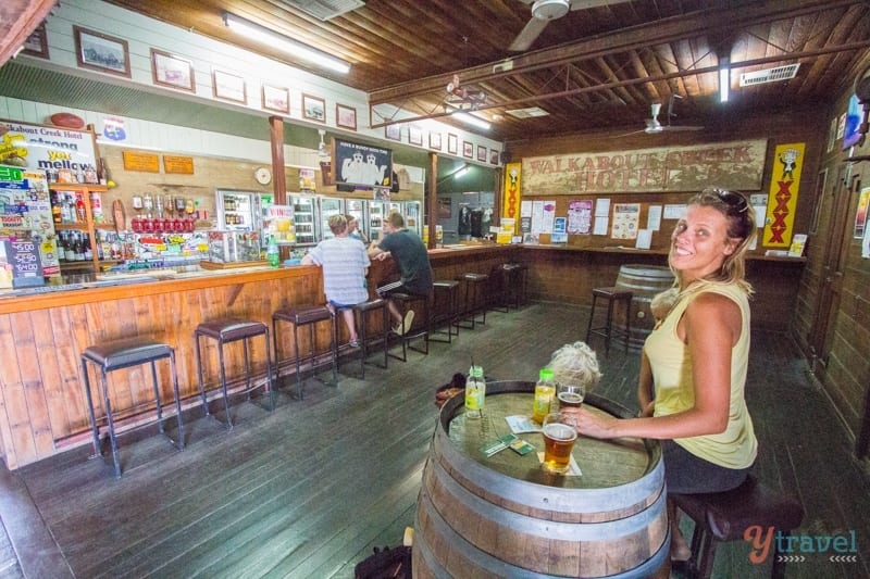 woman sitting at barrel in pub drinking beer