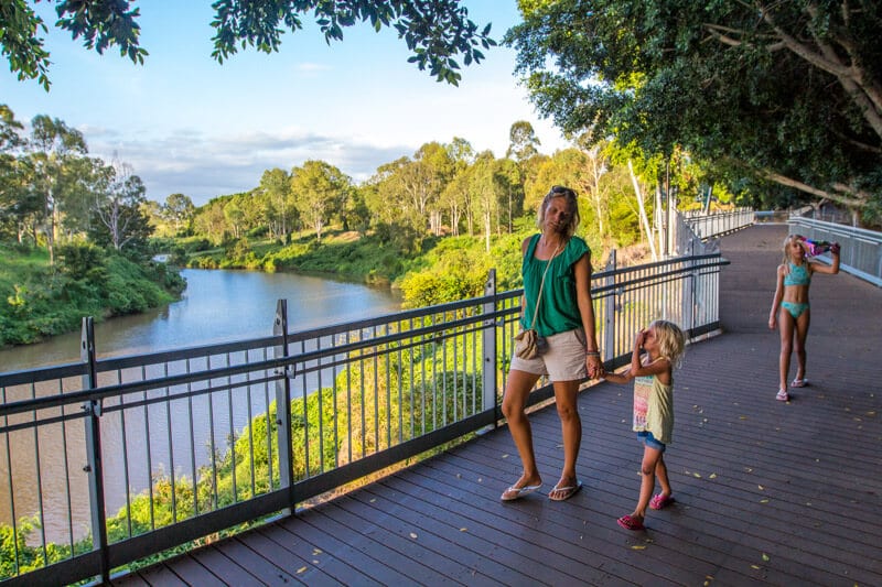 woman and child waljking on boardwalk above river