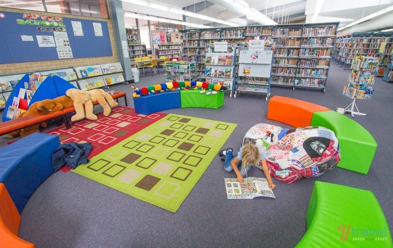 girl reading in a kids section of the library