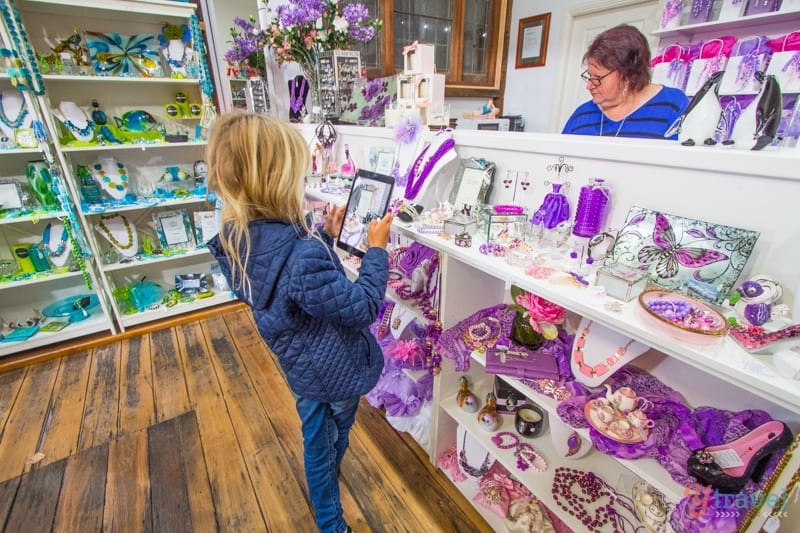 little girl taking photos of items at a store