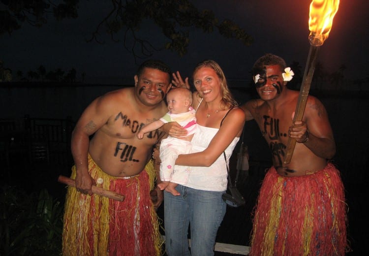 mother and child posing with Fijian men in skirts