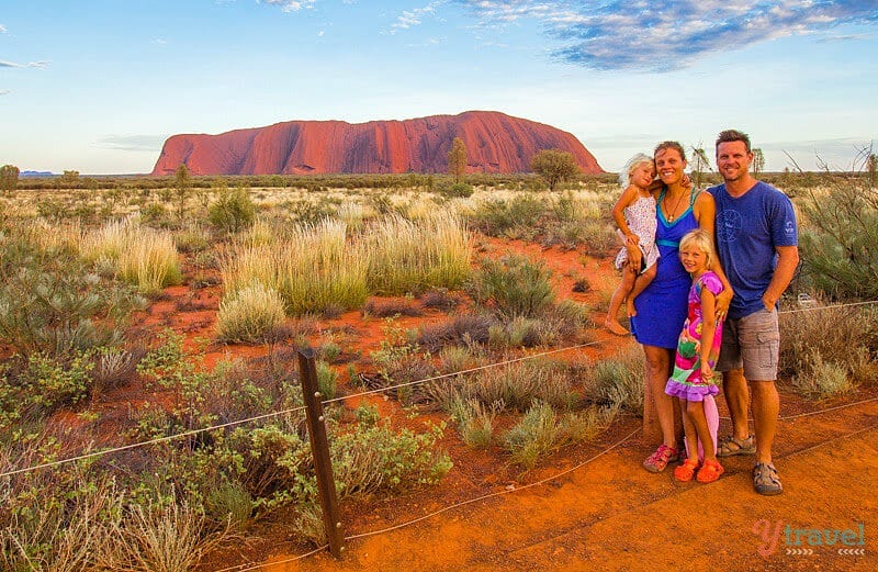 family posing in front of uluru