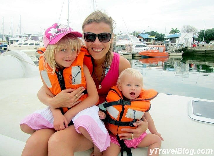 a woman and children wearing life jackets on a boat