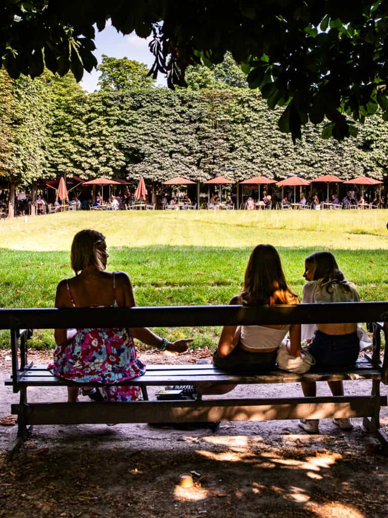 Mom and two daughters sitting on a chair in the garden.