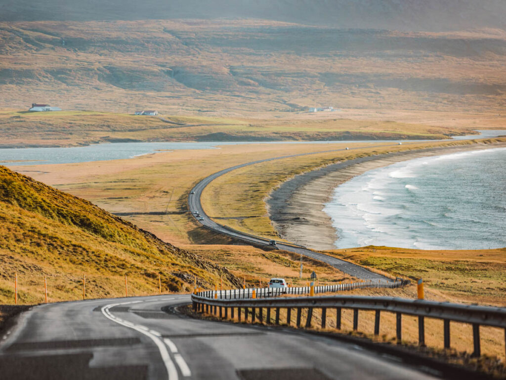 car on Empty road trough Iceland near the sea on a beautiful sunny autumn day.