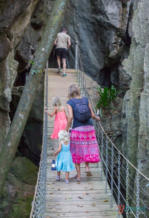 people walking across a rope bridge