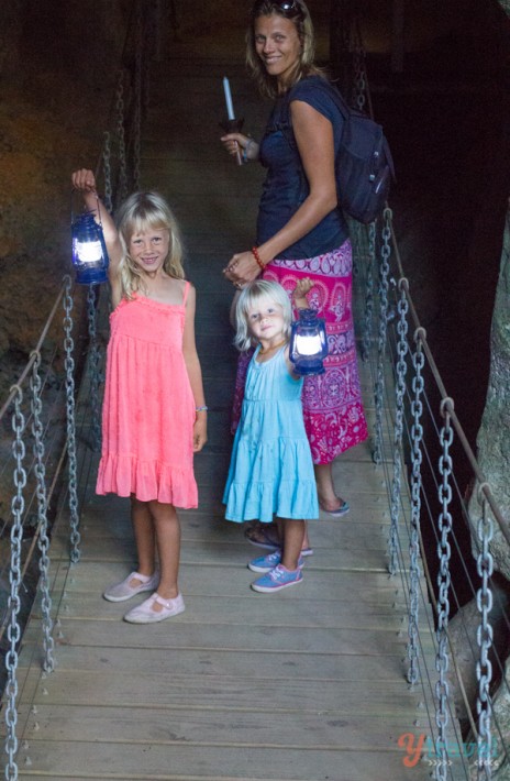 people standing on a bridge holding lanterns