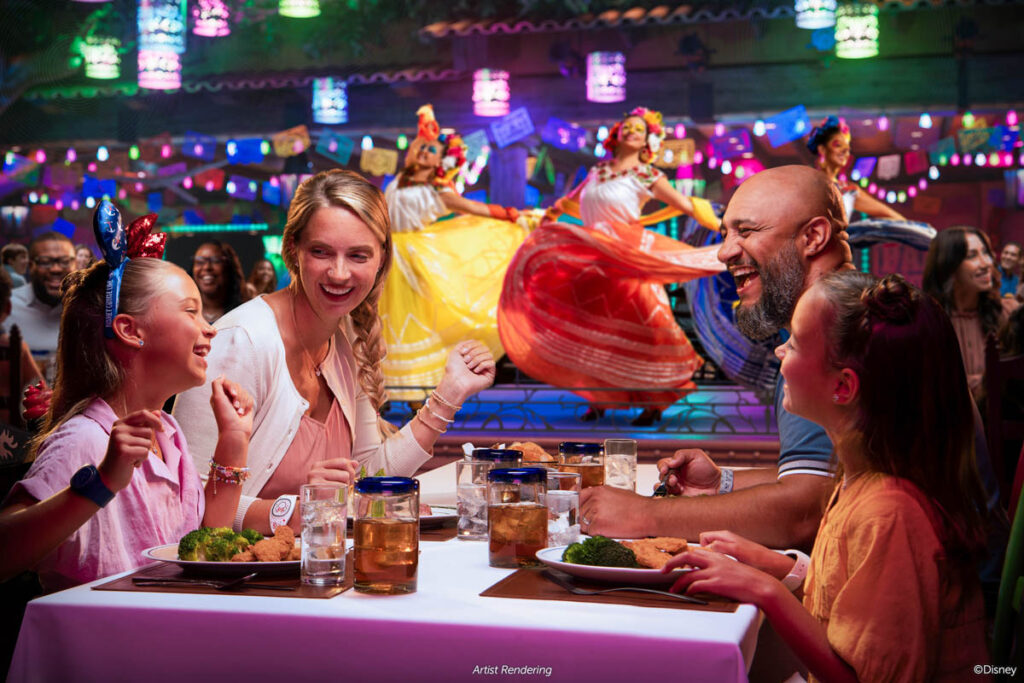 family eating dinner on disney treasure while coco and family sing on stage