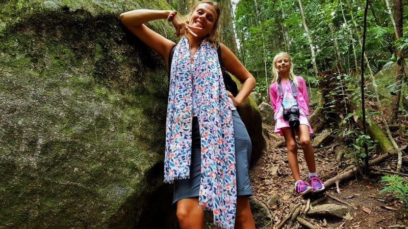 mother and child posing beside rock on  trail