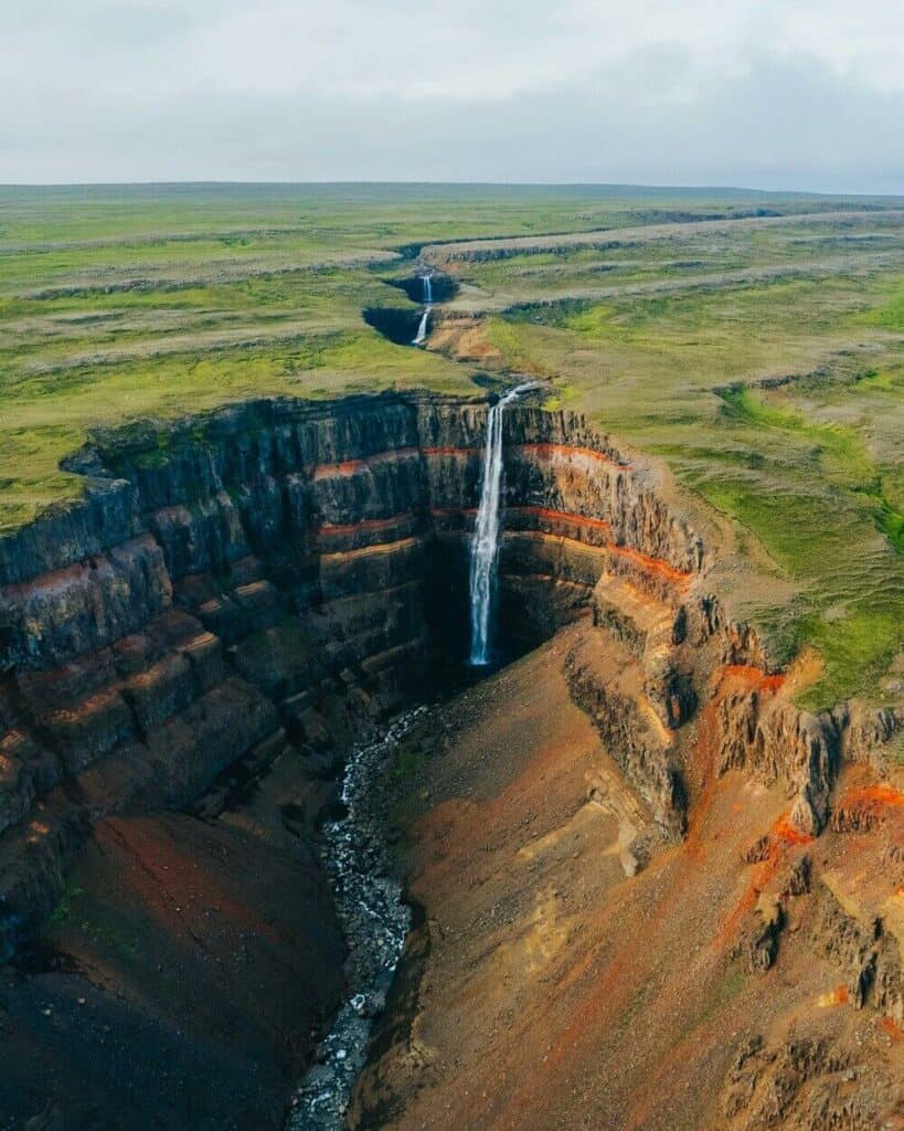 Hengifoss Waterfall spilling into orange canyon