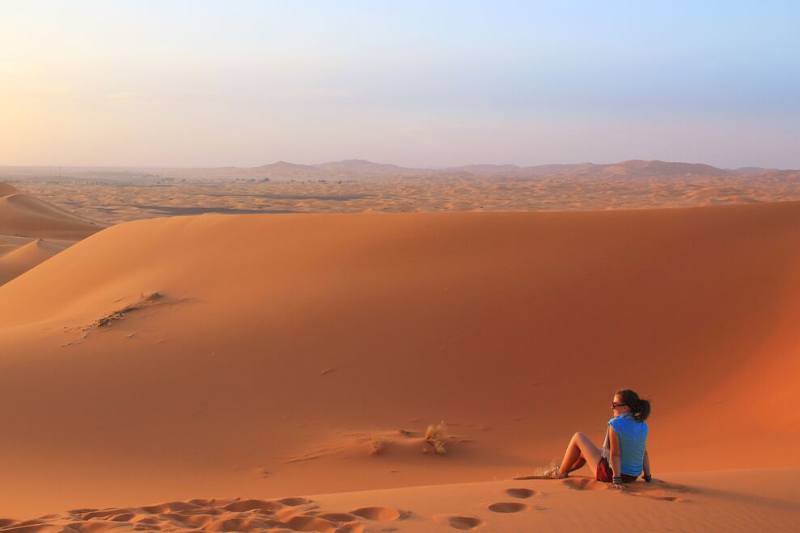 woman sitting on a sand dune