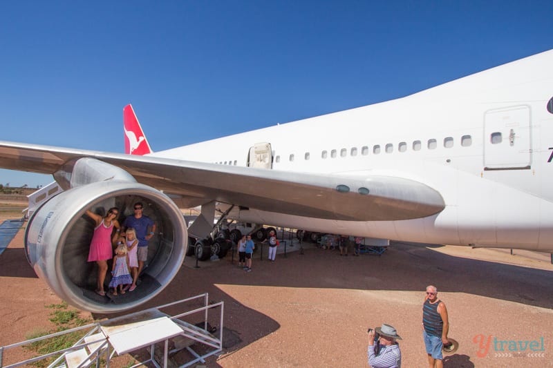 family standing inside jets of Qantas plane