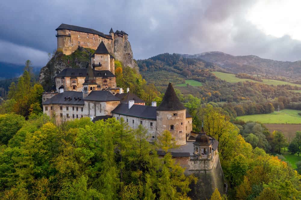 Orava Castle high on a hill with lush valley surrounding it