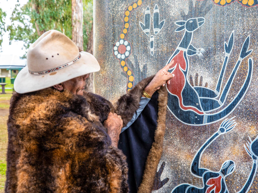 aboriginal elder pointing to rock art