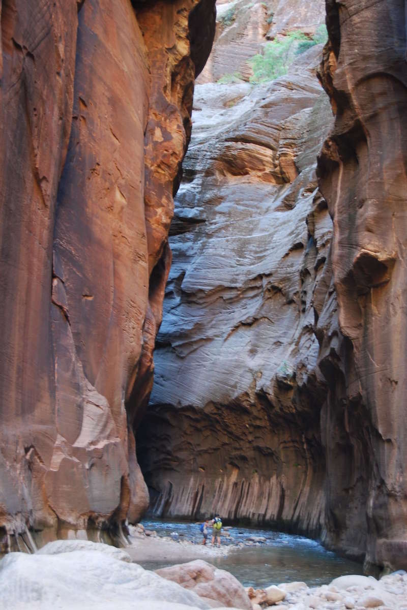 perspn in river beside steep canyon walls of narrow