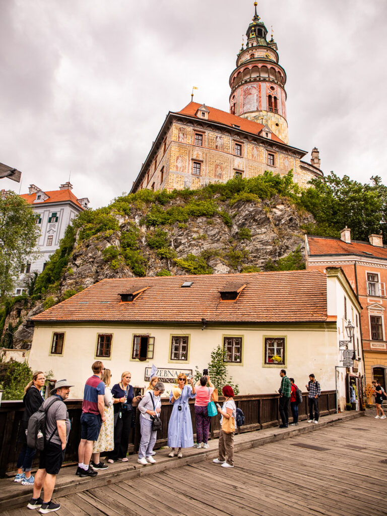 castle on top of hill and people standing underneath