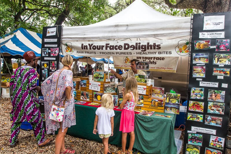 people looking at a market stand