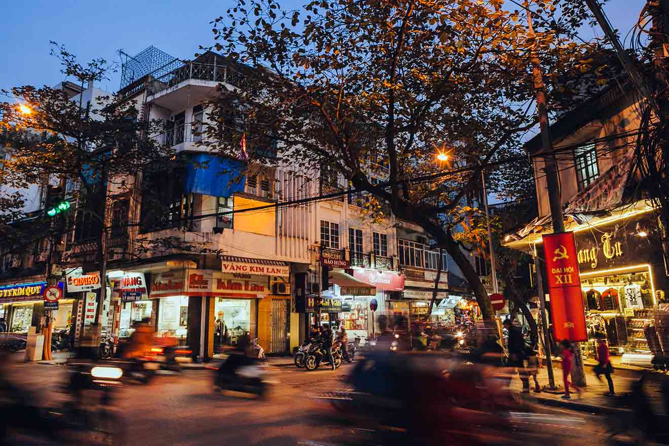 Evening bustle of Hanoi with blurred motion of scooters on the street, showcasing the vibrant nightlife and urban culture