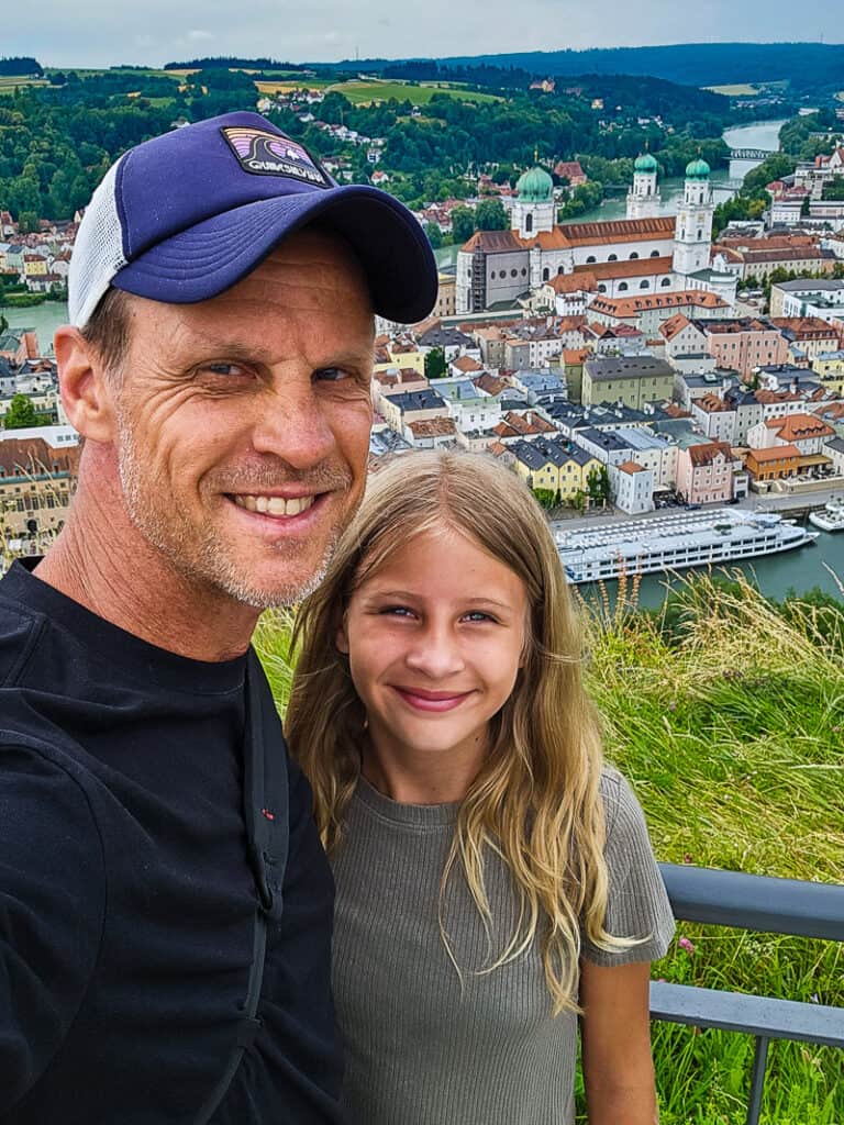 Dad and daughter taking a photo together with a city backdrop below