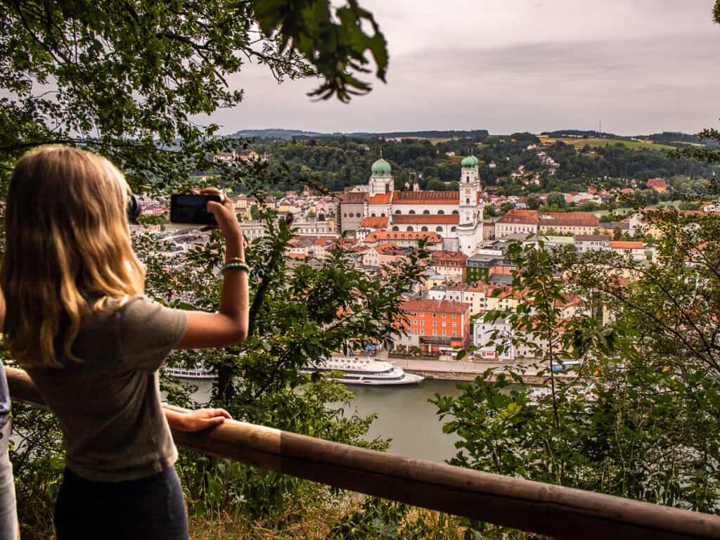 Girl taking photos of a city and river below