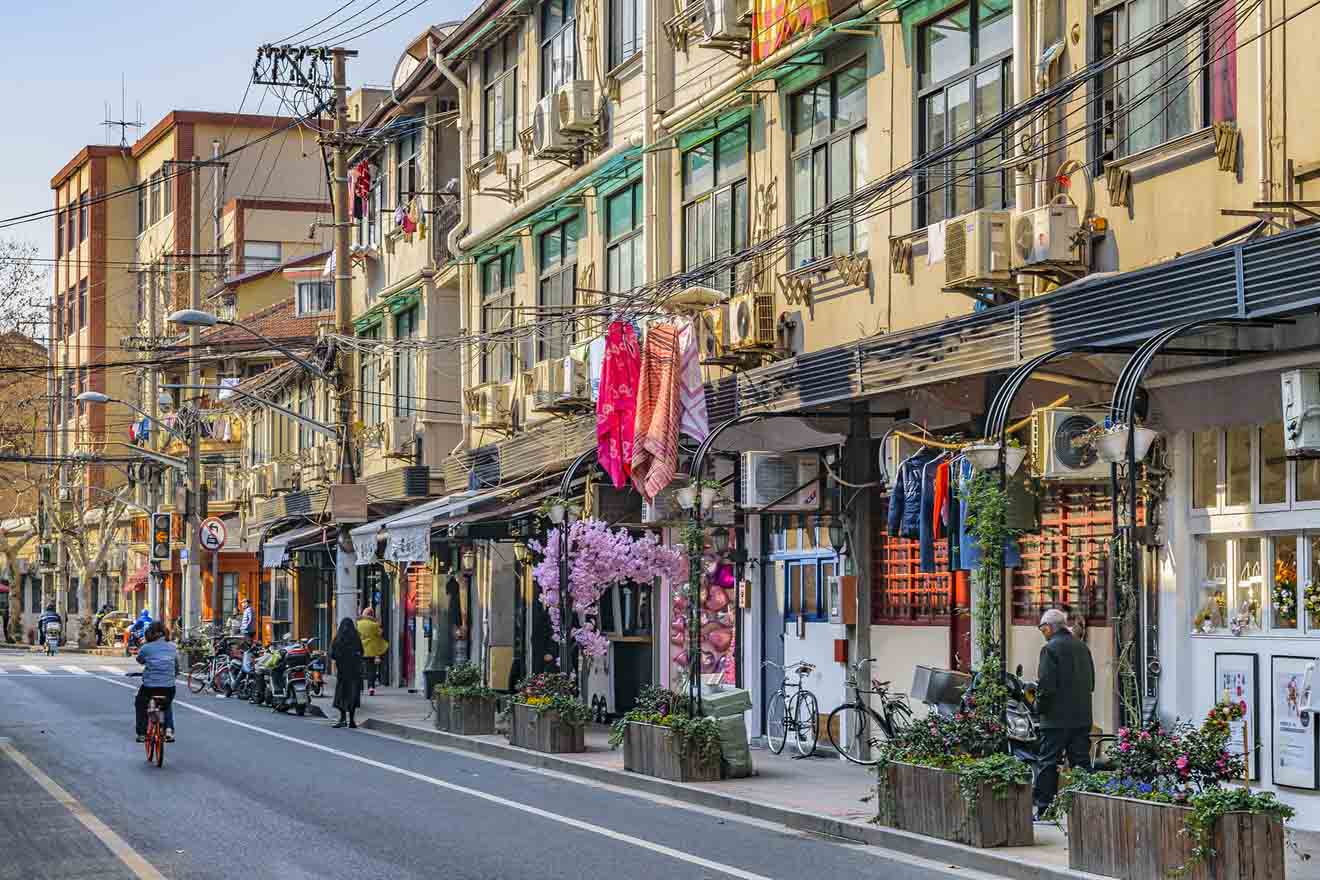 Quaint street in the Former French Concession of Shanghai, lined with shops and laundry hanging outside the buildings