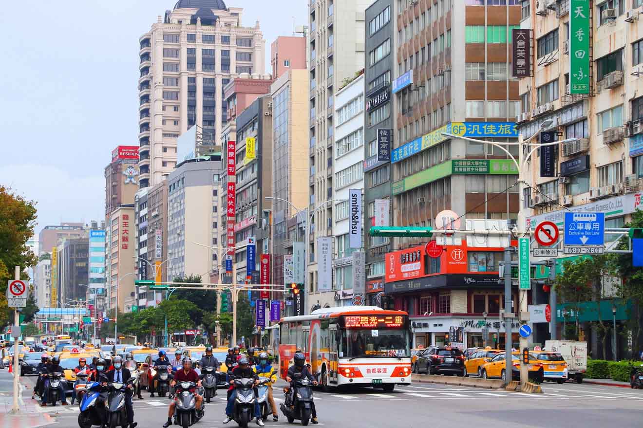 Busy Taipei street scene with scooters, buses, and cars amid colorful storefront signs