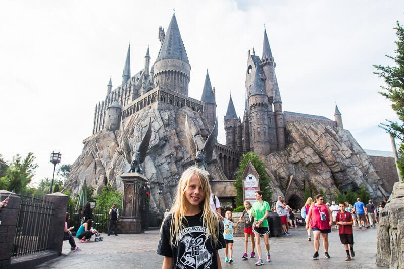 girl posing in front of Hogwarts Castle at Hogsmeade in Universal Orlando Resort