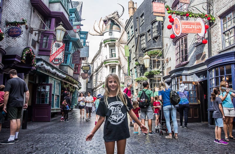 girl standing in the middle of Diagon Alley - inside Universal Studios Orlando Parks